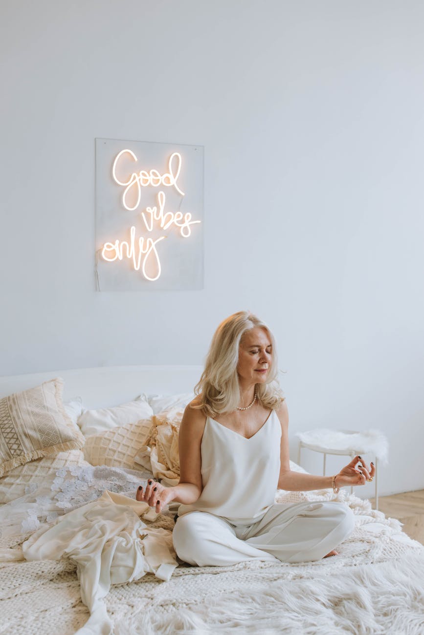 woman in white tank top sitting on bed